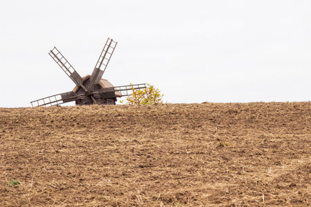 The top of an old wooden mill against the sky. Plowed land. Copy space.の写真素材