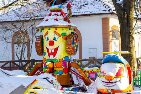 Children's attraction with laughing figures in a winter park. Building in the background.の写真素材