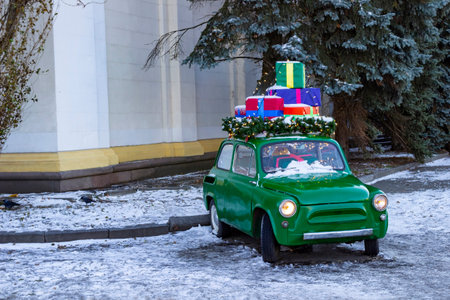 Vintage small green car with gifts. Snow on the road.の写真素材