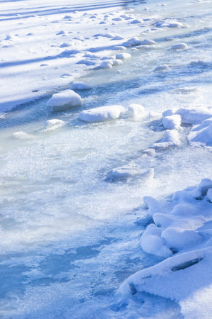 The river is covered with ice. Long shadows on the ice.の写真素材