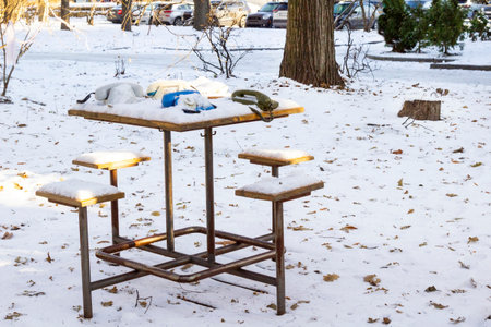 Old models of phones on a table in the yard. Snow on the table and on the ground.の写真素材