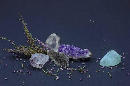 semiprecious stones: amethyst, rhinestone, smoky quartz,  aquamarine and heather branch on a dark backgroundの写真素材