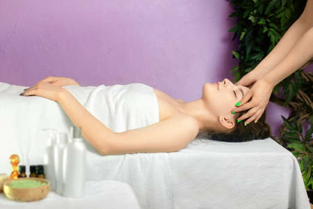 Beautiful young woman resting on a massage table. Rest and relaxation in the spa.の写真素材