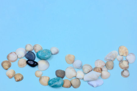 seashells, white, blue and black stones on a blue background. amazonite and sea pebbles