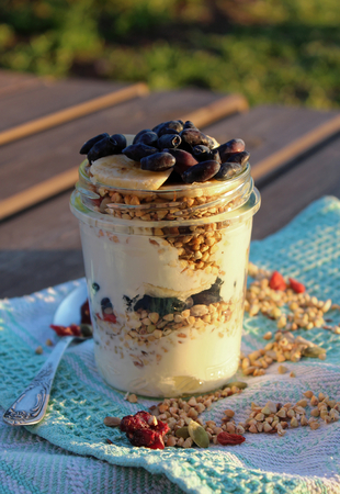 Granola with bananas and honeysuckle on wooden tableの写真素材