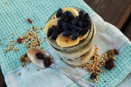 Granola with bananas and honeysuckle on wooden tableの写真素材