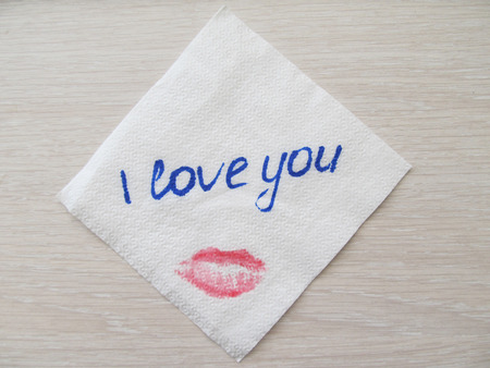 Inscription I love you on a white napkin, a print of female lips, to write with handsの写真素材