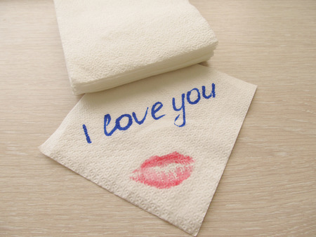 Inscription I love you on a white napkin, a print of female lips, to write with handsの写真素材