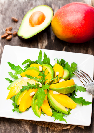 Fresh  vegetarian salad with mango and avocado in white squared plateの写真素材