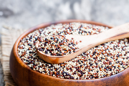 close  up of a wooden bowl with quinoa seeds on a old tableの写真素材