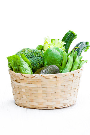 Fresh  green vegetables in wicker basketの写真素材