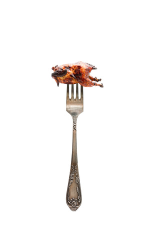 Small  grilled chicken on a big fork. Food balance choice portion concept. の写真素材