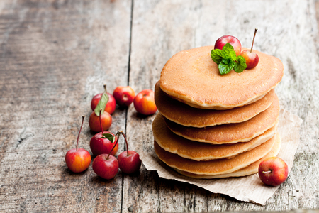 Stack of pancakes with fresh wild apples on wooden tableの写真素材