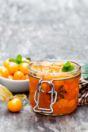 Homemade  physalis jam in jar on wooden table の写真素材