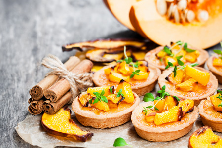 delicious  tartlets with baked honey pumpkin and cinnamon on rustic background の写真素材