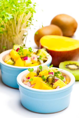 Dietetic  salad in the pot with kiwi and mango isolated on white の写真素材