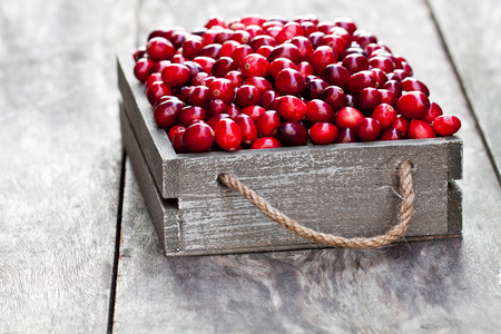 fresh  cranberry in a wooden box on rustic table の写真素材