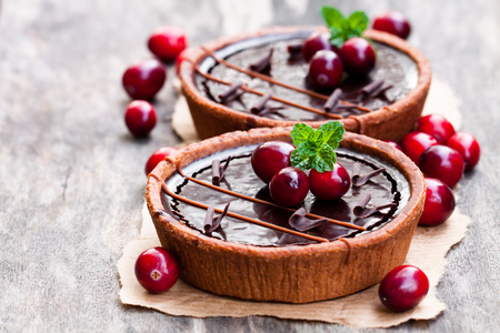 mini  chocolate tarts with cranberries on wooden background の写真素材