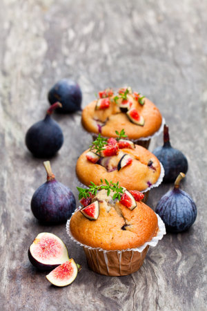 Baked  muffins with figs on rustic wooden table 