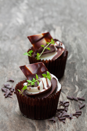 Chocolate  cupcakes with cream on wooden table の写真素材