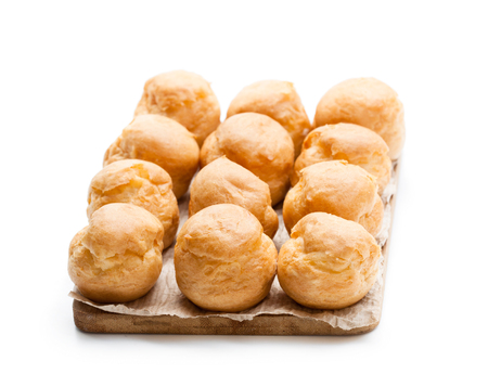 Homemade  profiteroles on wooden board isolated on whiteの写真素材
