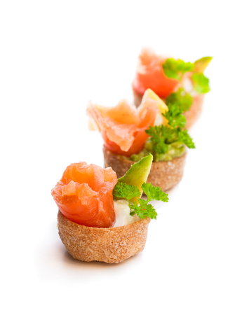 Croustades  crispy pastry cases filled with salted salmon and avocado isolated on whiteの写真素材