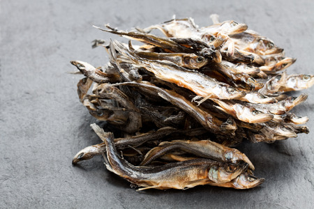 Heap  of dried fishes on black stone backgroundの写真素材