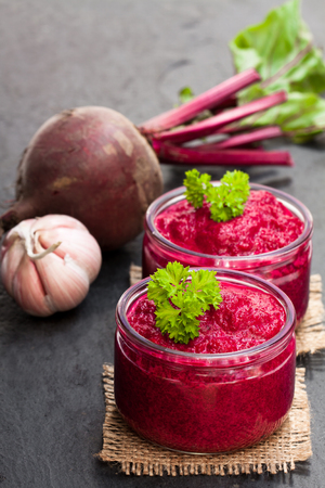 Beetroot  puree in glass jars on black stone backgroundの写真素材