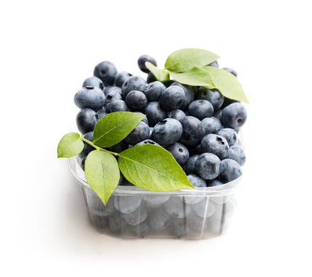 Fresh  blueberries in smal plastic container isolated on whiteの写真素材