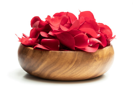 Heap  of red rose petals in wooden table isolated on whiteの写真素材