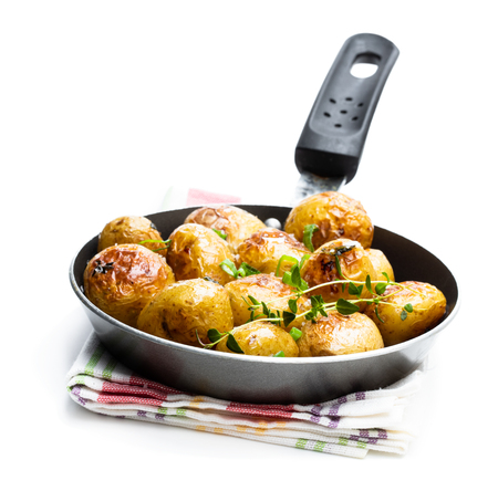 Baked  baby potatoes in a frying pan isolated on whiteの写真素材
