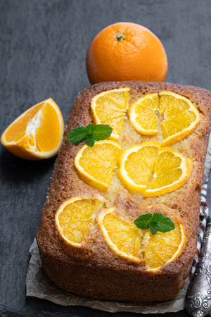 Homemade  orange syrup cake on black stone backgroundの写真素材