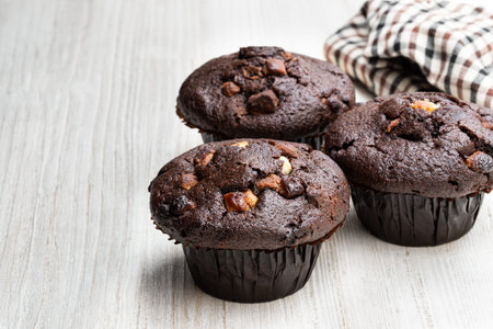 Triple  chocolate muffins on white wooden tableの写真素材