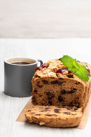 Mixed  fruit loaf cake with cup of coffee on wooden tableの写真素材