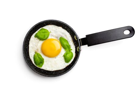 Fried  egg with basil leaf on small pan isolated on whiteの写真素材
