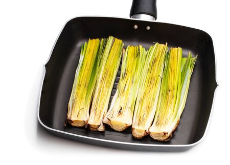 Grilled  baby leeks in frying grill pot isolated on white の写真素材