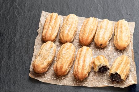 Homemade  baked mini chocolate filled churros on black stone background の写真素材