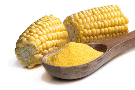 Corn grits polenta in wooden spoon isolated on whiteの写真素材