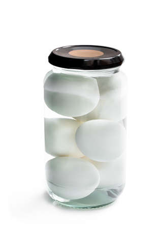 Pickled  eggs in the glass jar isolated on whiteの写真素材