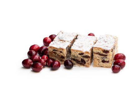 Christmas stollen slices with cranberry with icing sugar isolated on whiteの写真素材