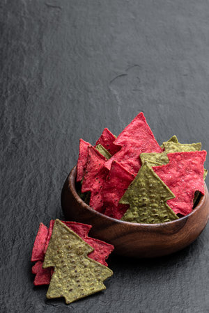 Christmas  tree shapes tortilla corn crisps on black stone backgroundの写真素材