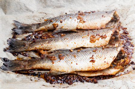 Oven baked mackerel with lemon and ginger on baking paperの写真素材