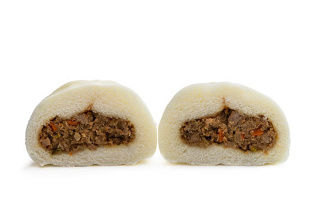 Two halves of the same steamed bao bun showing filling isolated on white backgroundの写真素材