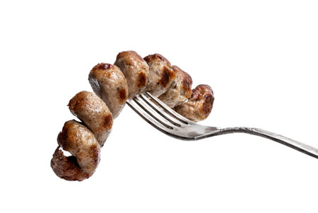 Grilled  spiral sausage on a fork isolated on white
