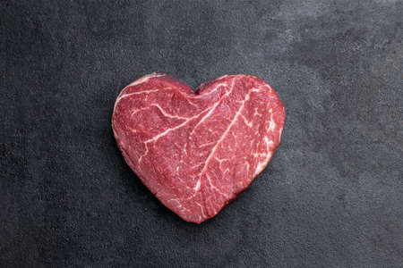 Heart shape raw fresh beef steak on metal backgroundの写真素材