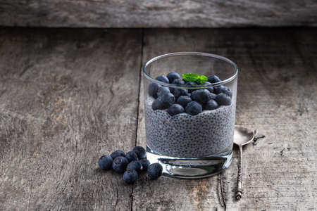 Chia seed pudding with blueberry in clear glass on wooden tableの写真素材