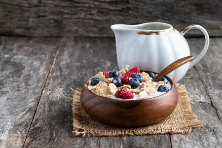 Rice  and wholewheat cereal flakes with dried and fresh berries on wooden tableの写真素材