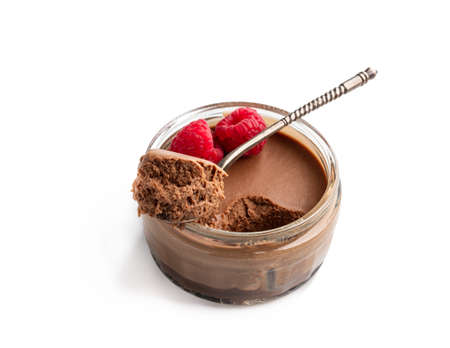 Mini  caramel cheesecake in a glass pot with spoon isolated on whiteの写真素材