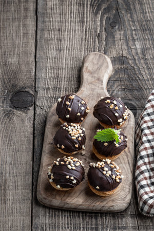 Round chocolate cookies filled with toffee cream on wooden table