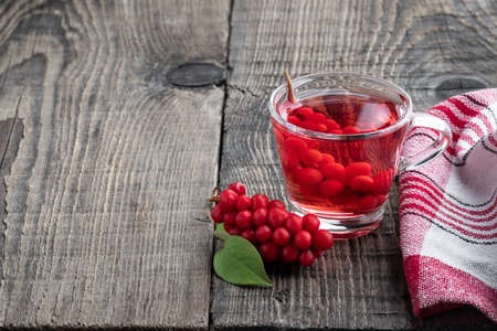 Schisandra tea in clear glass cup on wooden tableの写真素材